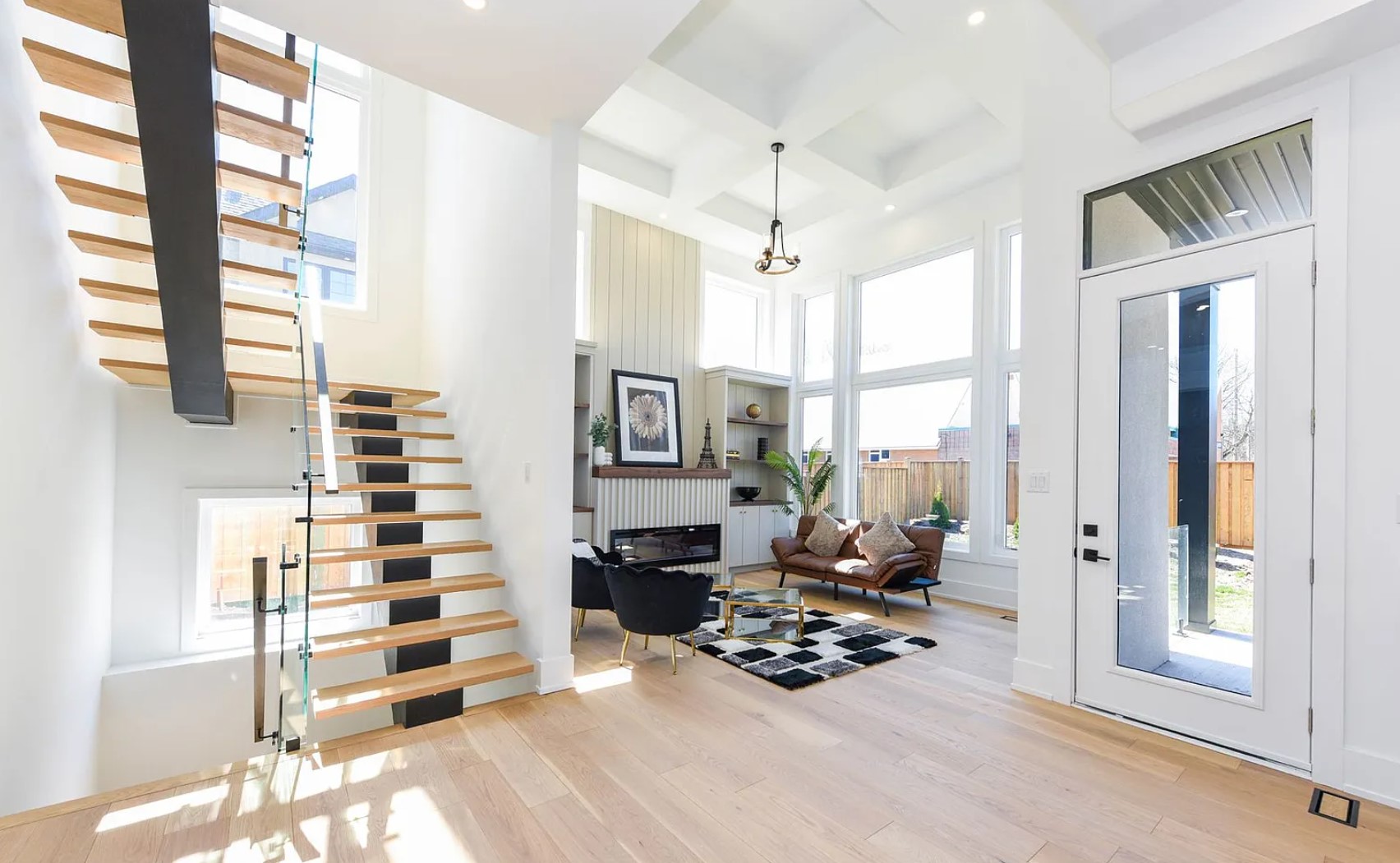 J94 H2 Burlington living area with oak staircase, glass railing and bright interior