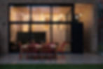 An urban narrow lot property promoted by Lucky Homes Realty, featuring a minimalist exterior and highlighting a small outdoor terrace that extends the living space.