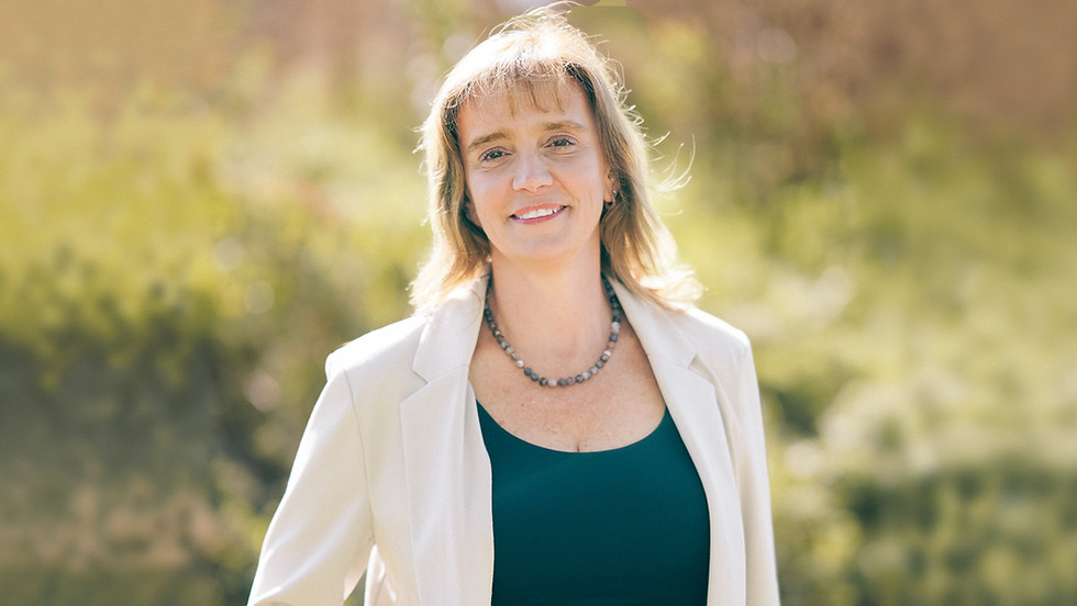 Nathalie Duquette, CPA et associée, souriante à l’extérieur, par une journée ensoleillée.