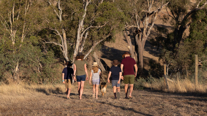 Family of 5 walks dog on rural property