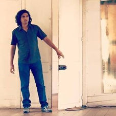 David Furlong in rehearsals as Ashique in a white painted wooden house