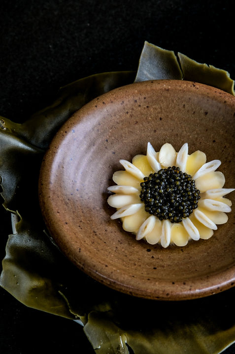 Close-up of L’Arôme by the Sea’s gourmet dish featuring razor clam with caviar and parmesan custard, plated elegantly on a fine dining ceramic plate.