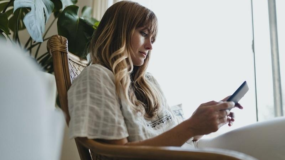 Person searching through online therapist directory profiles from home using a phone.