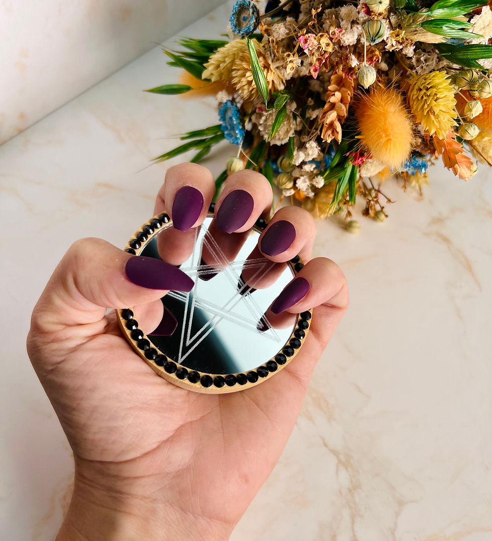 Miniatura: Espejo con una estrella de cinco puntas grabada sujeto por una mano semi cerrada