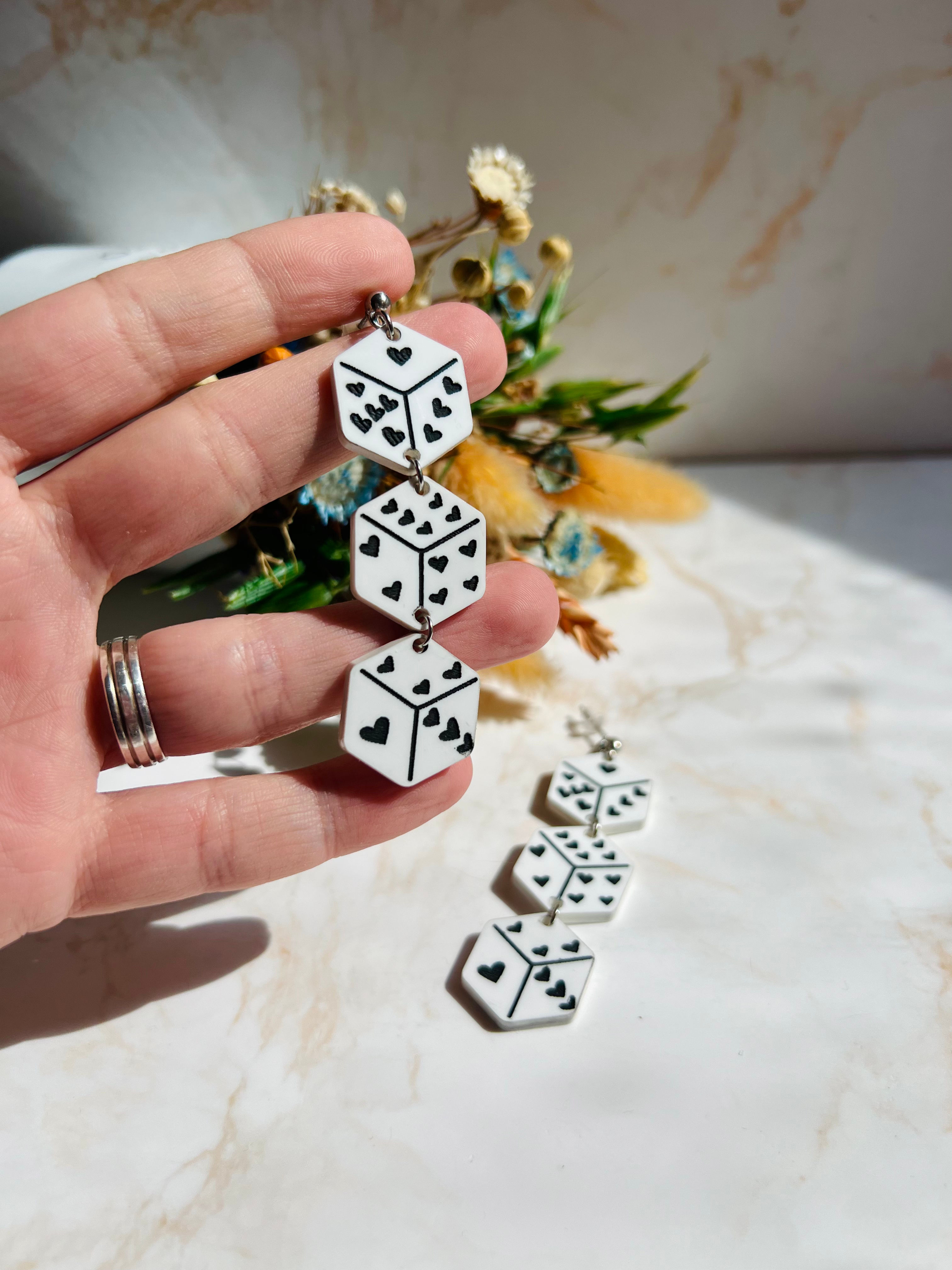 detalle de Pendientes dado de metacrilato blanco con corazones negros