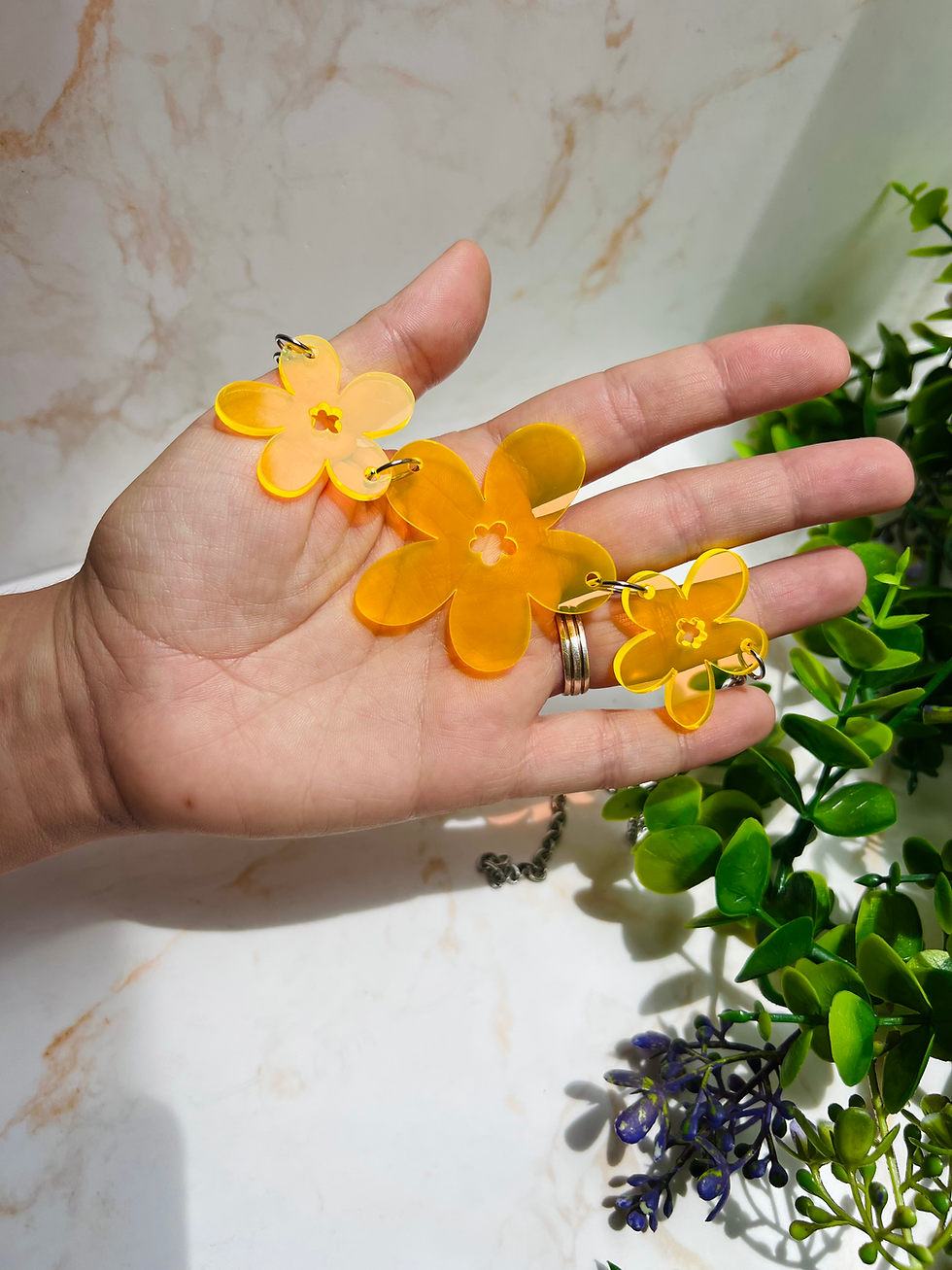 Collar de margaritas efecto fluor traslúcido en metacrilato con cadena de acero hipoalergénico sobre mano