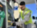 Senior Biologist and Standards Specialist Ryan Atwood replaces stickers on a gas pump.