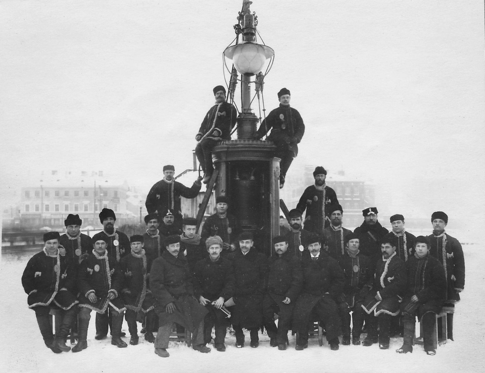 Группа рабочих Акционерного общества электрических сооружений «Гелиос» у установленного ими уличного фонаря. Фотография ателье Буллы. [нач. 1900-х гг.], Фото из архива комитета Санкт-Петербурга, https://spbarchives.ru/