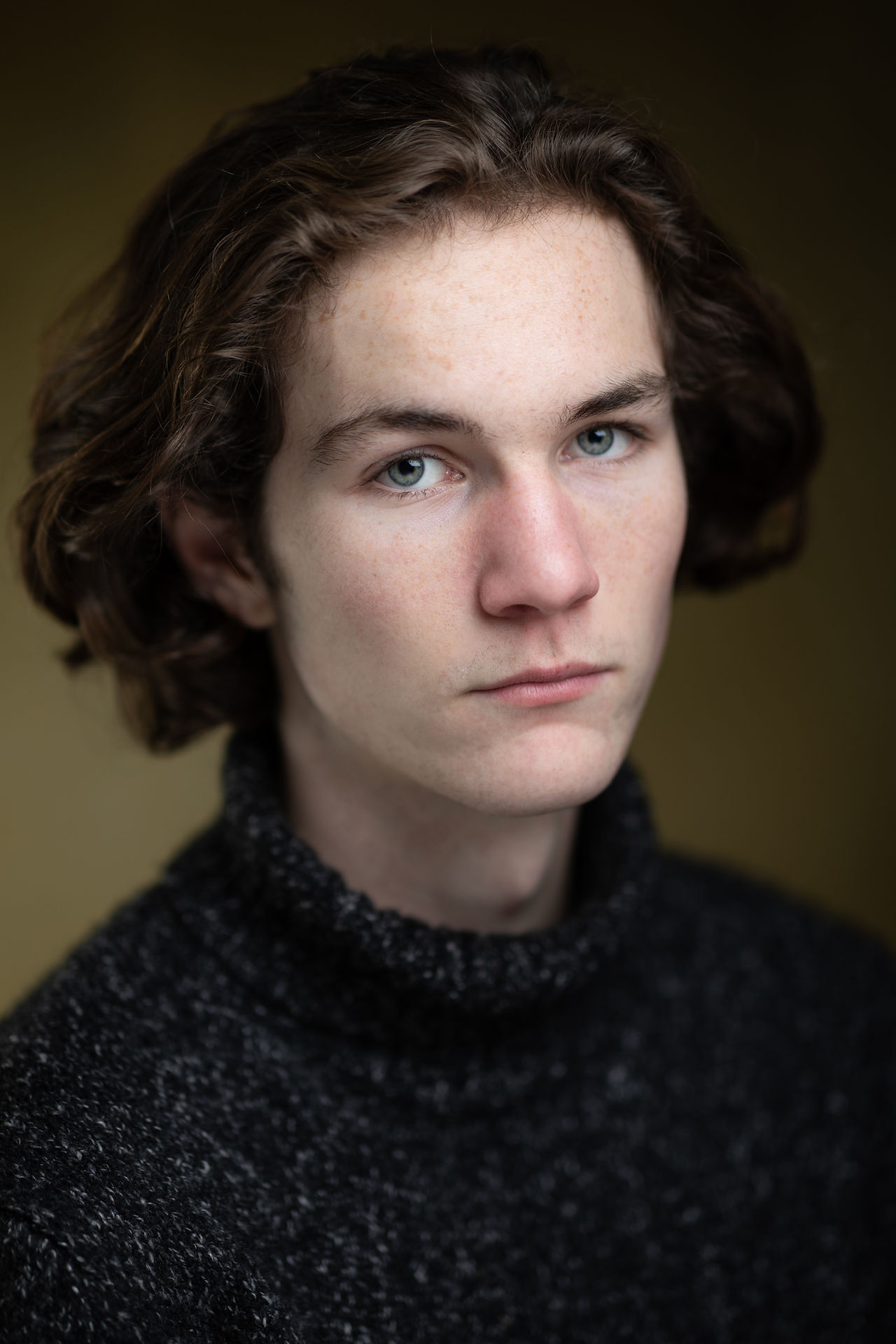 headshots - male actor headshot against an olive background