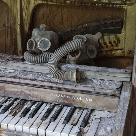 two crusty gas masks on a dusty old piano with broken keys