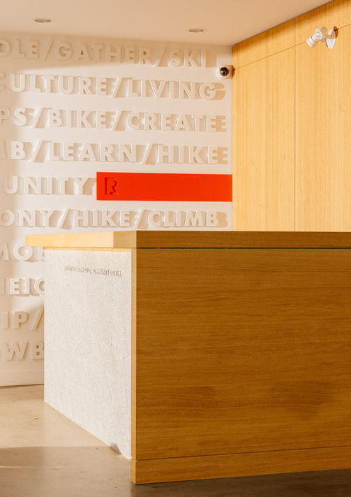 3D Letter Wall behind millwork reception desk and redbridge logo