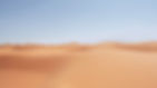 Vast expanse of sand dunes under a clear blue sky