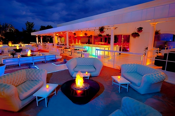 Coin lounge LMER installé en terrasse : deux canapés Chesterfield et une table basse, prêt pour un cocktail.