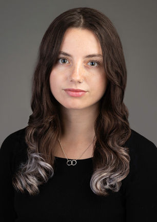 studio headshot of a lovely young woman with beautiful hair and necklace