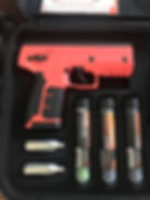 A red Byrna SD non-lethal launcher in a case with two cartridges and three projectile tubes labeled ECO-KINETIC and KINETIC PROJECTILES.