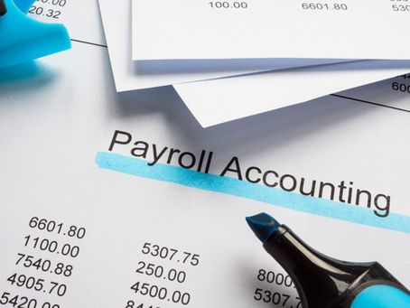 Document titled Payroll Accounting, with blue highlighter. Papers show numbers and a sense of organization. Bright lighting.