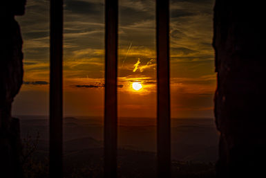 Durch das Gitterfenster ist ein wunderschöner Sonnenuntergang in der Eifel zu sehen
Wandbilder zum kaufen