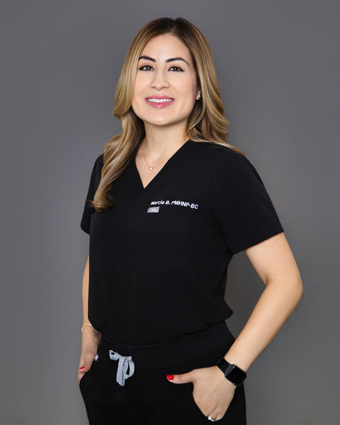 Professional portrait of a woman in black scrubs  in a modern studio setting with a warm smile by Tina Dwyer Photography