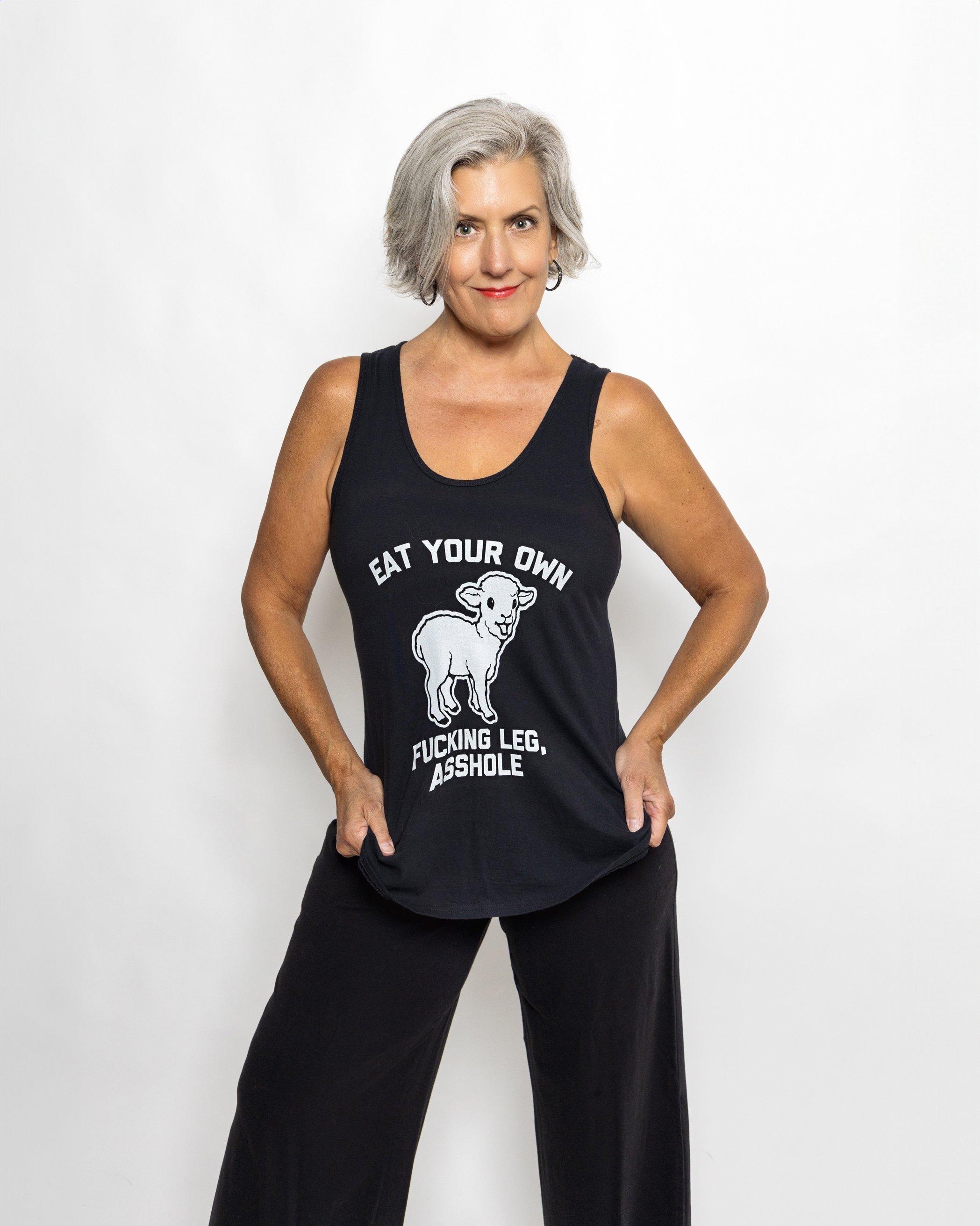 Confident full-length portrait of a woman in a tank top and black pants, by Tina Dwyer Photography