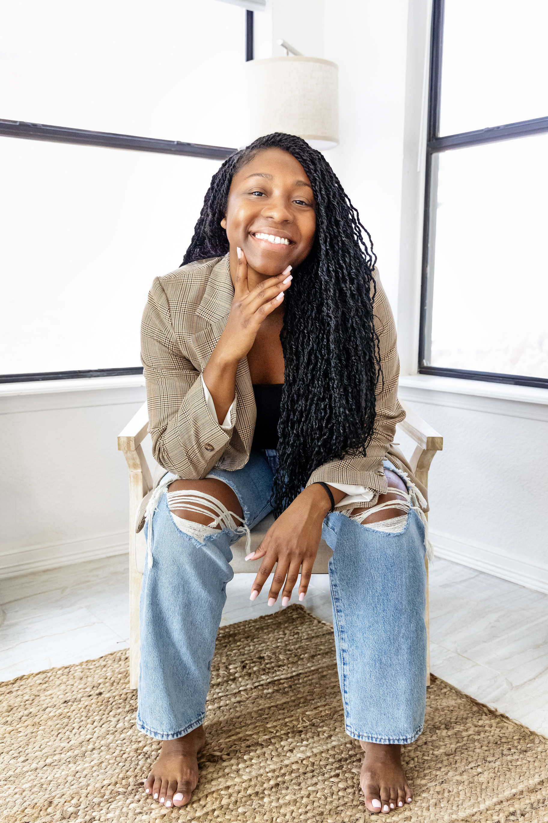 Casual branding portrait of a woman in a tan jacket seated and smiling, by Tina Dwyer Photography El Paso