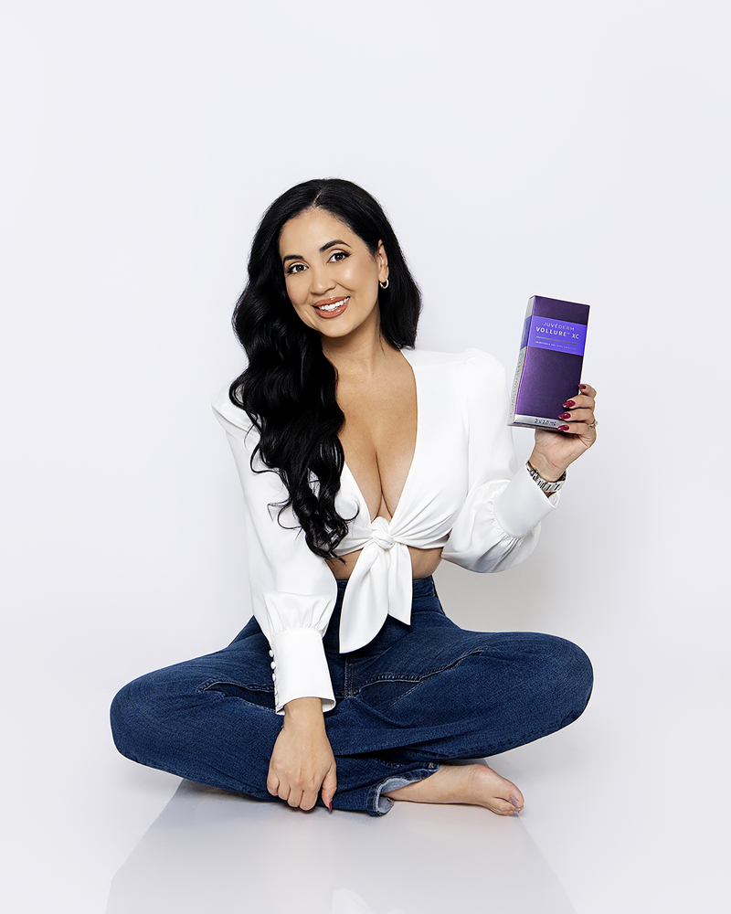 Professional branding portrait of a woman in a white top and jeans holding a smartphone, photographed by Tina Dwyer Photography in El Paso