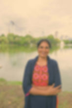 portrait-smiling-young-woman-standing-against-lake (1).jpg