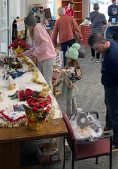 People gather at kanab library for a craft sale and raffle.