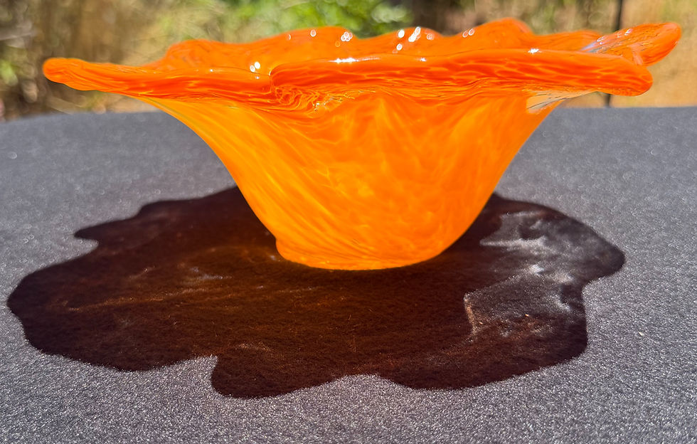 Orange glass bowl front view showing ruffled shape and pointed edge