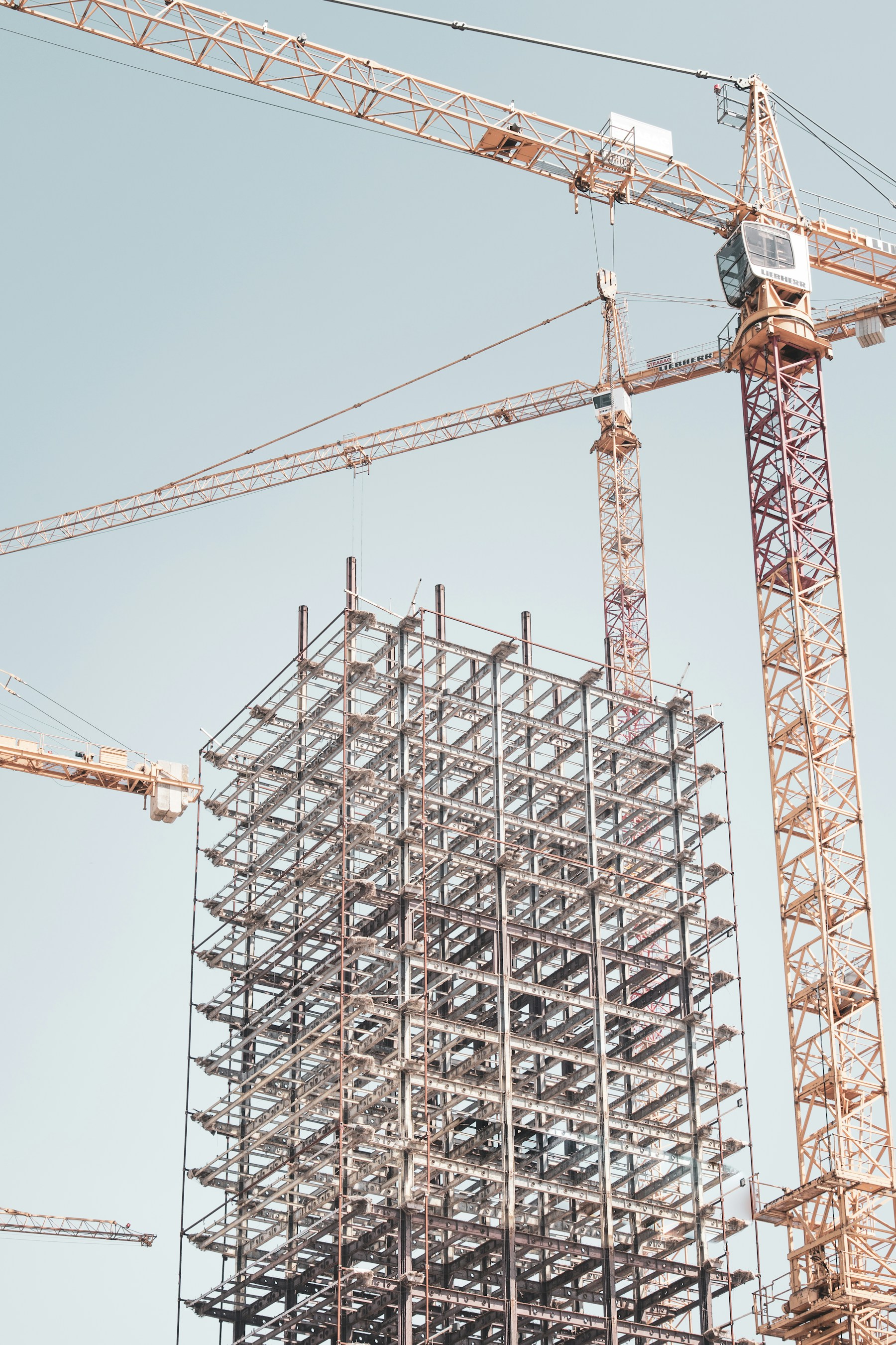 Real structural steel building frame and tower crane during construction