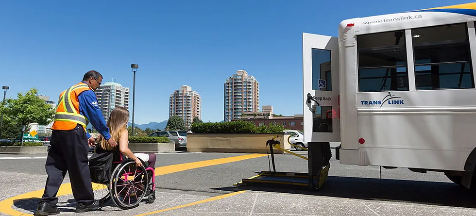 A man helping a woman in a wheelchair onto a large transit van