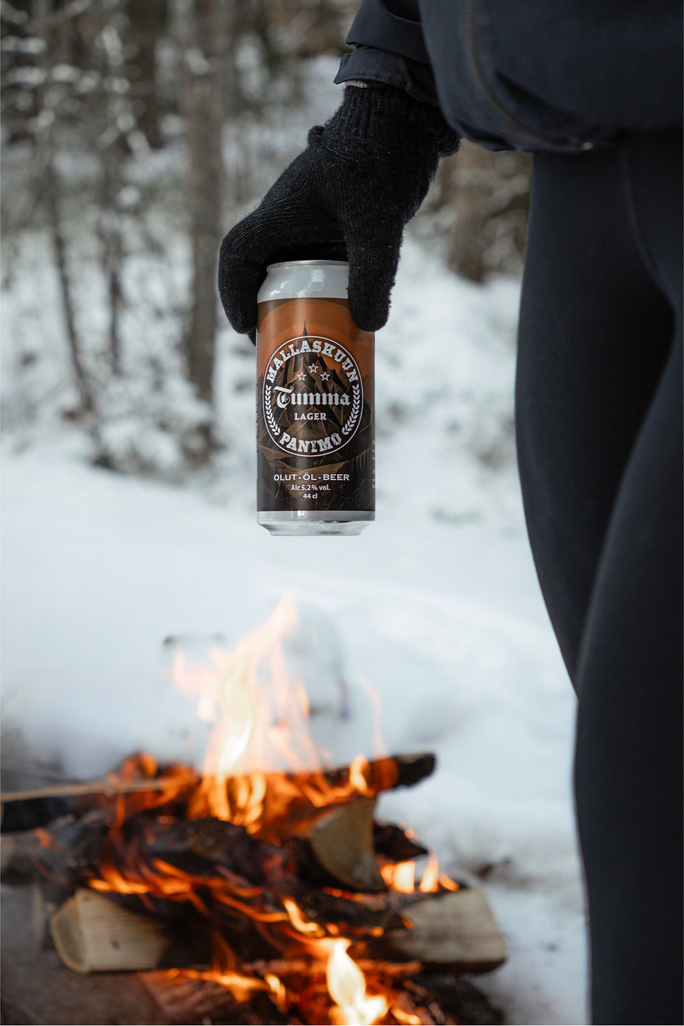 Mallaskuun Panimon Tumma Lager -olut talvisessa metsämaisemassa