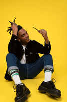 Photo book d'un homme en noir qui tient ses cheveux dreadlocks assis sur fond jaune coloré pour une agence de  publicité par Guillaume Marbeck Photographe à Paris 8