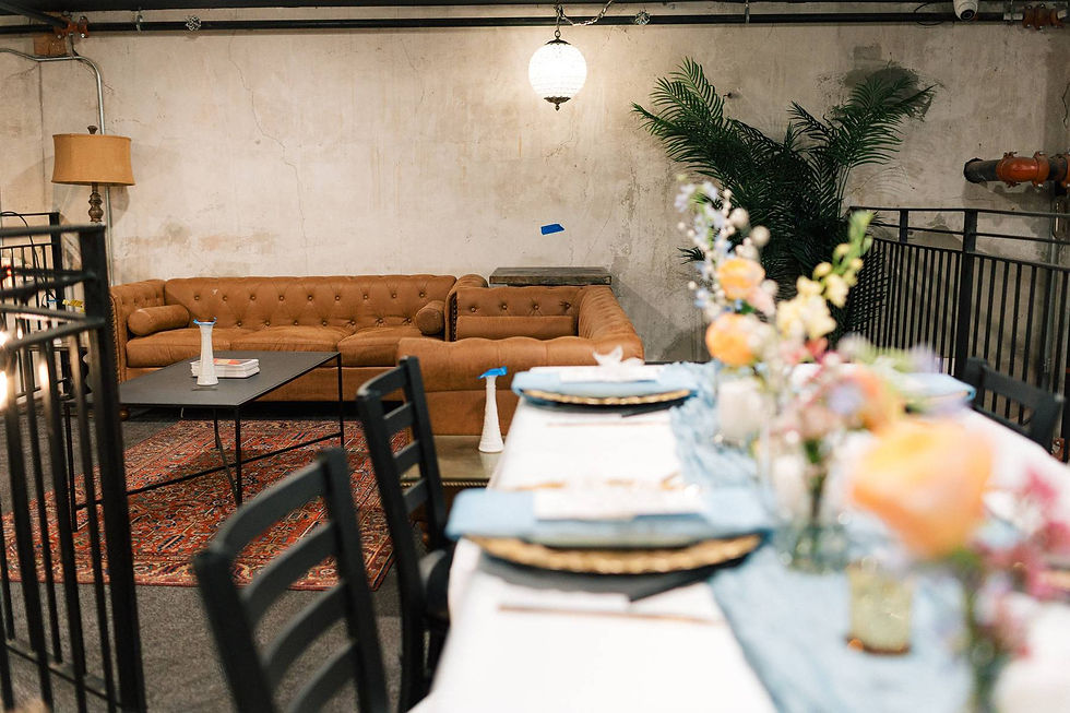 Eye-level view of a wedding table set with simple floral arrangements and candles provided by venue