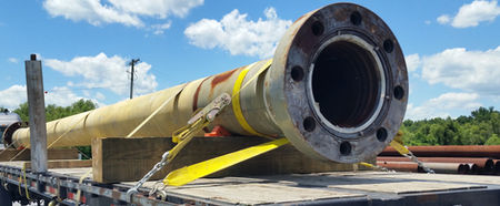 A flanged drilling riser joint strapped to a flatbed trailer