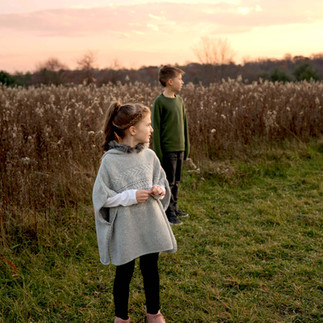 A brother and sister look over a beautiful field during sunset in North Park. 