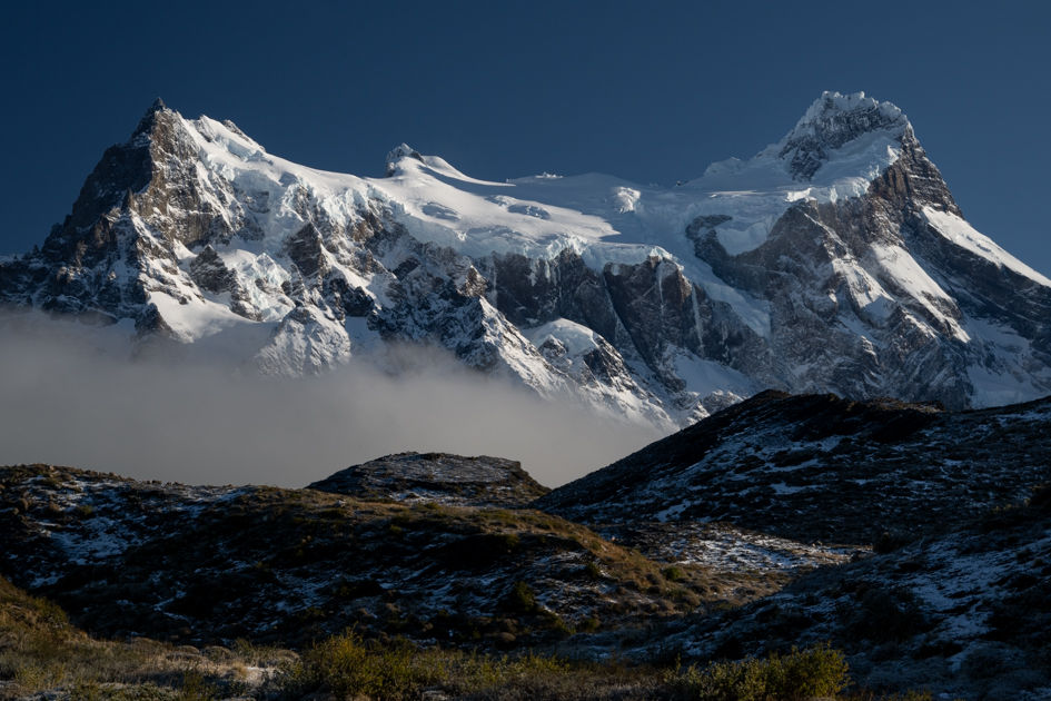 Snow-covered mountains glowing with early morning light in Patagonia.