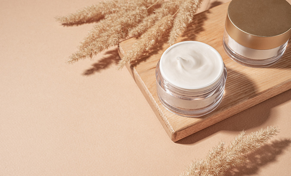 Jars of cosmetic cream with pampas grass on pastel beige background, copy space Nourishing