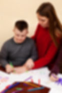 woman-helping-boy-with-down-syndrome-draw.jpg