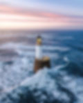 Waves hitting a lighthouse in Scotland.jpg