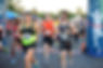 A group of runners taking off from the starting line as the Buffalo Stampede Half-Marathon and 5k Race starts.