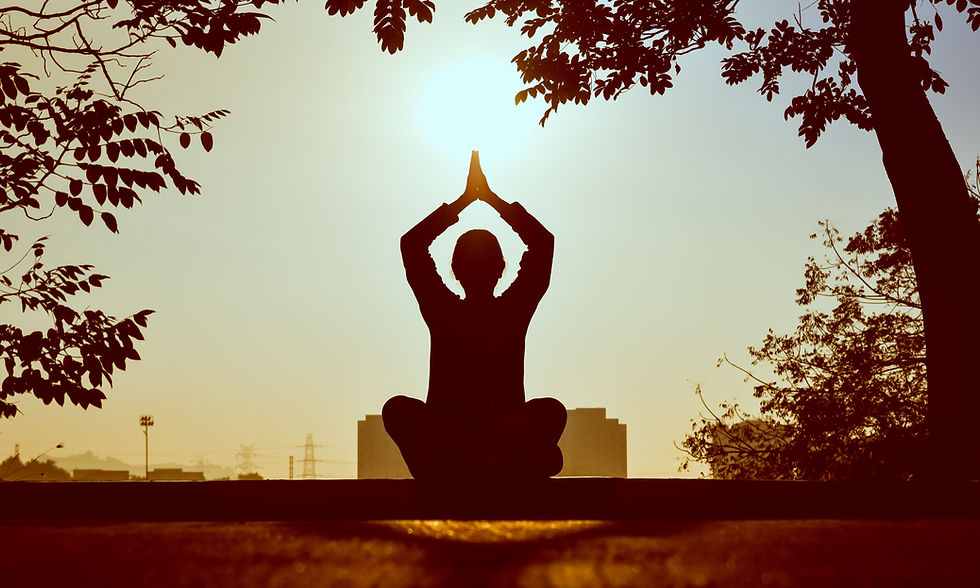 Silhouette of a man meditating at sunset