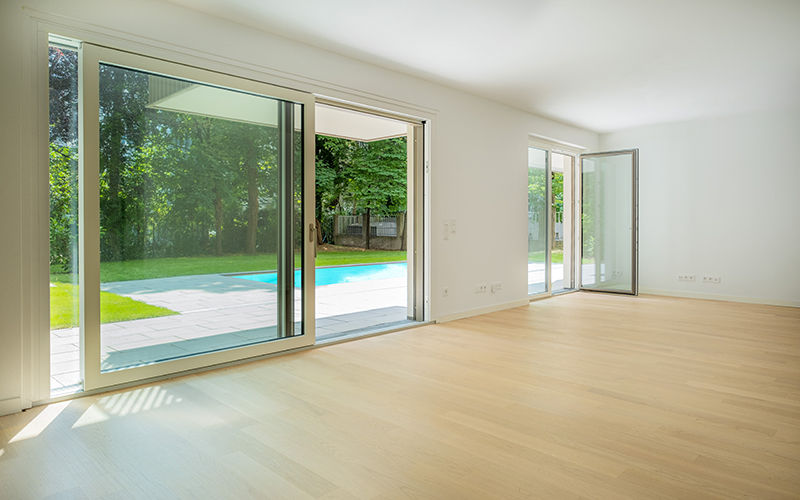 Großer Wohnraum mit Echtholzboden und bodentiefen Fenstern im Wohnprojekt YOUNG LIVING 19 in Wien-Döbling.