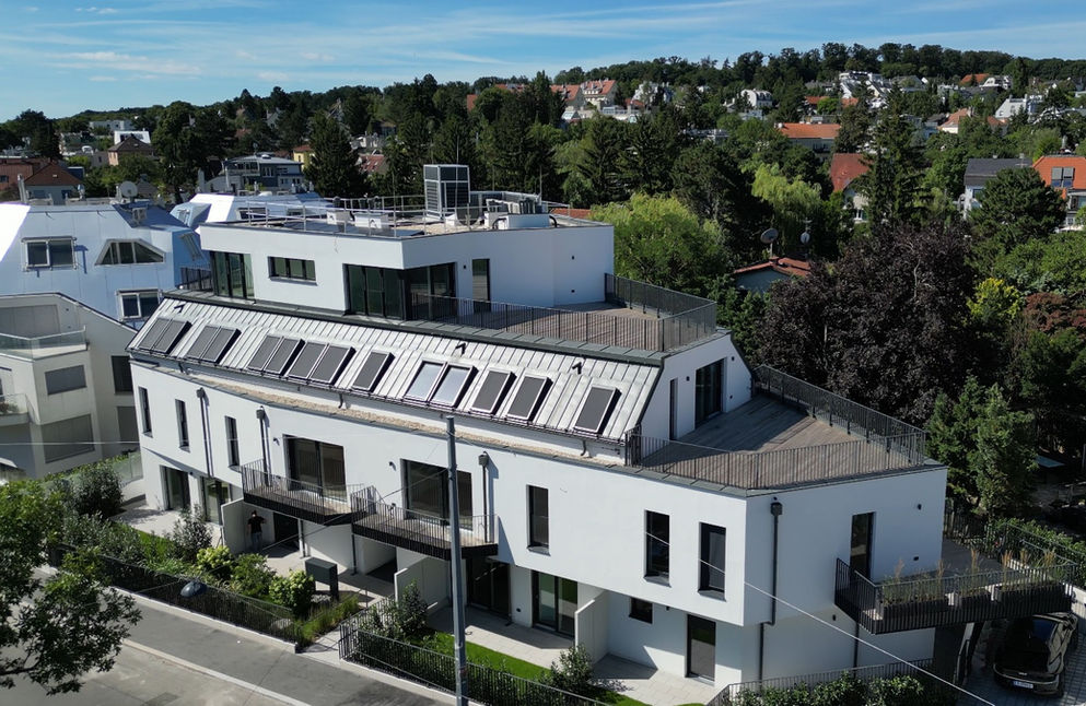 Luftaufnahme des Neubauprojekts in der Jagdschlossgasse 75, 1130 Wien, mit moderner Architektur, großen Terrassenflächen und Blick auf die grüne, villenartige Nachbarschaft des 13. Bezirks.