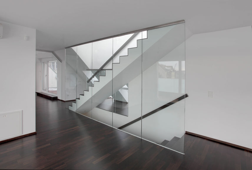 Glasverkleidetes Stiegenhaus mit modernen Architekturdetails im Projekt The Greens.