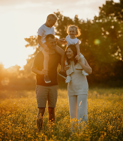 a family standing in a buttercup meadow at sunset