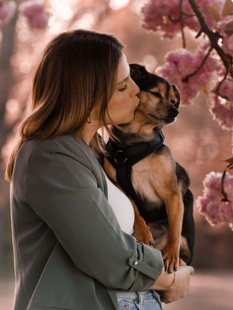 Einfühlsame Hundefotografie in Mainz. Die Frau trägt ihren Hund auf dem Arm und küsst diesen.
