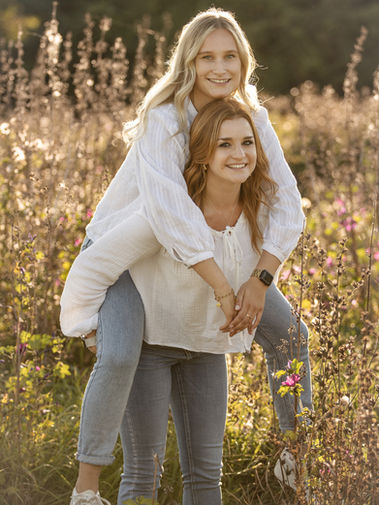 Natürliche Freundebilder in Groß-Gerau. Eine junge Frau trägt die andere Huckepack.