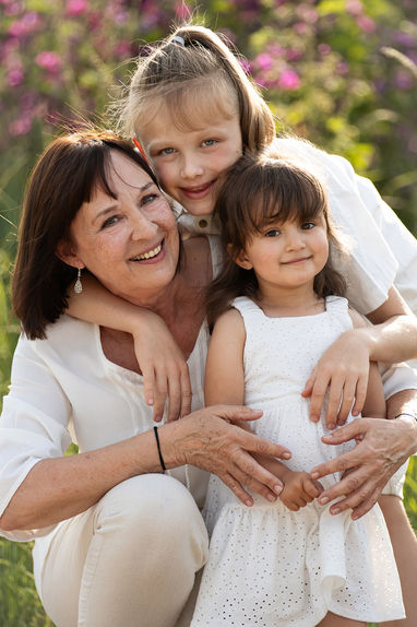 Authentische Familienfotografie in Groß-Gerau. Eine Frau und ihre zwei Enkelkinder kuscheln sich aneinander.