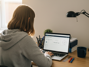 London student seen from behind using a laptop for strategic maths revision with percentages, quadratics and circle geometry during an online lesson.