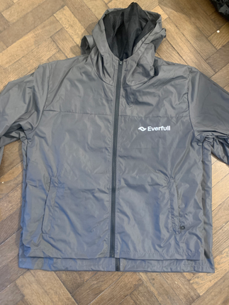 Campera gris con capucha, cierre frontal y logo de Everfull aplicado en el pecho.